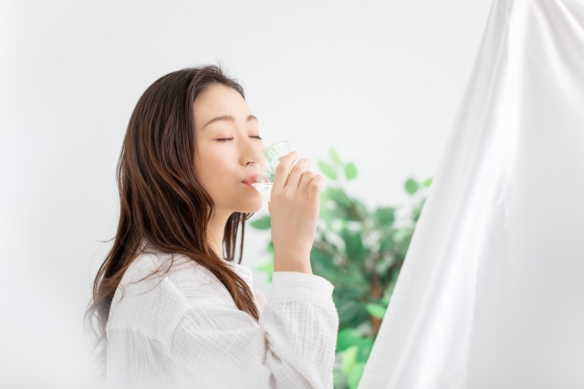 室内でもこまめに水分補給する女性